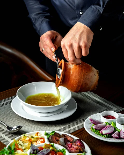 Людина п'є суп у тарілку — стокове фото