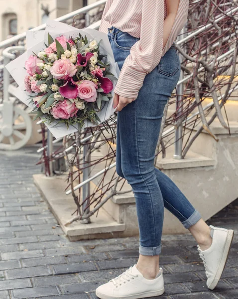 Femme tenant un bouquet de fleurs avec de grandes roses roses et de petites roses crème, cals violets — Photo