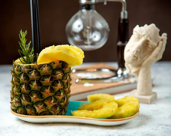 pineapple juice in pineapple cup served with pineapple slices