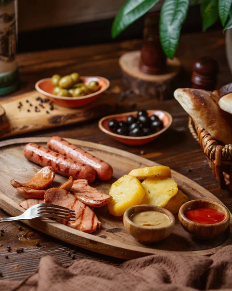 Grilled sausages plate with fried potatoes and mustard and ketchup — Stock Photo, Image
