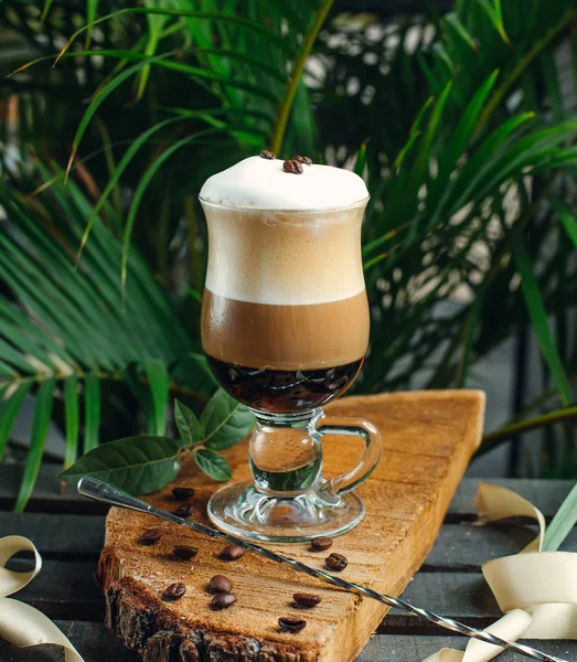 Καφέ στρωμένος με κρέμα γάλακτος και κόκκους καφέ σε ξύλο ρουστίκ — Φωτογραφία Αρχείου