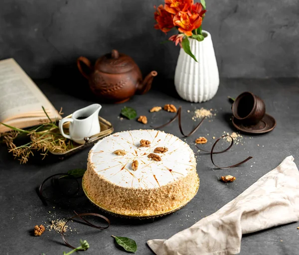 Белый глазурованный торт, украшенный крошками торта и грецкими орехами — стоковое фото