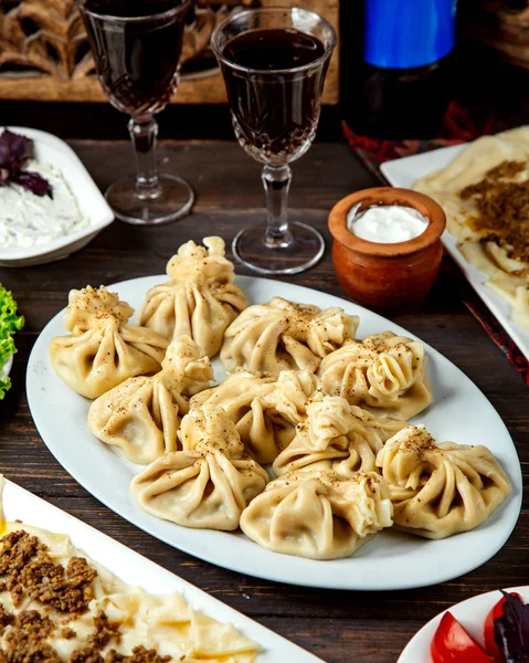 Khinkali géorgien épicé et verre de vin rouge — Photo