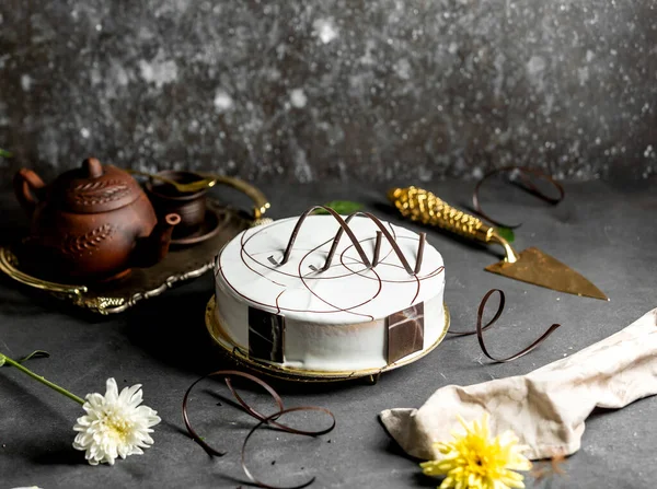 Круглый торт с белой глазурью, украшенный кусочками шоколада — стоковое фото