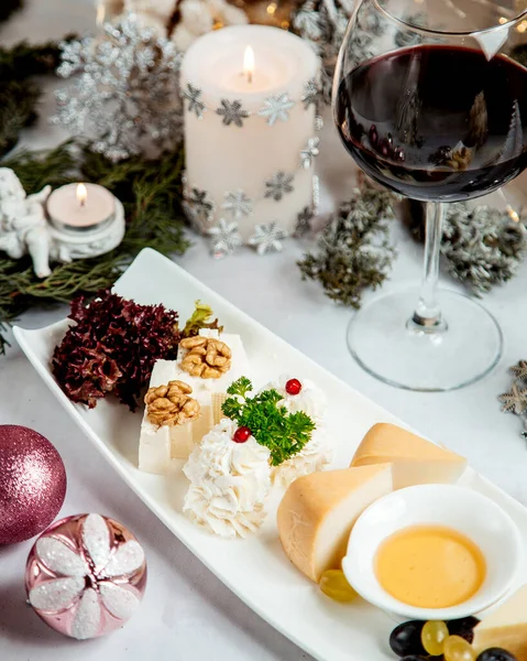 Cheese plate with walnuts and glass of wine — Stock Photo, Image