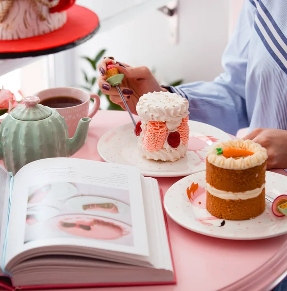 Kvinna äter portionerad maräng tårta med rosa grädde och hallon — Stockfoto