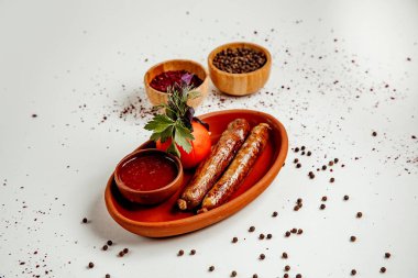 Domates ve ketçaplı kızarmış sosis.