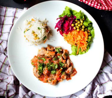 Pilav ve sebze soslu tavuk parçaları.