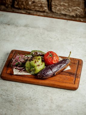 Kızarmış sebze, dilimlenmiş soğan ve otlar.