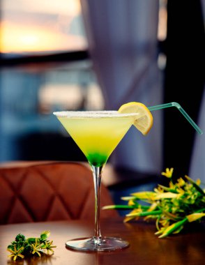 Kenarlarında tuz olan sarı-yeşil alkol kokteyli.