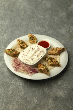 Düz ekmeğe sarılı lule kebabı yoğurt ve domates sosuyla servis edilir.