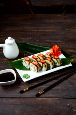 Üzerinde çilek dilimleri olan suşi ruloları.