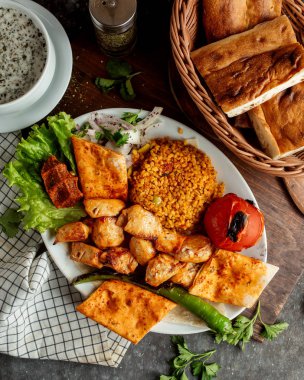 Kızarmış tavuk parçaları ve sebze ve yanında ekmek.