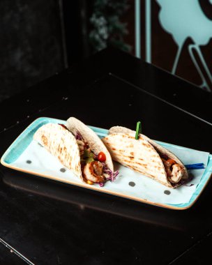 Tavuk dilimleri ve gözlemeye sarılmış sebzeler.