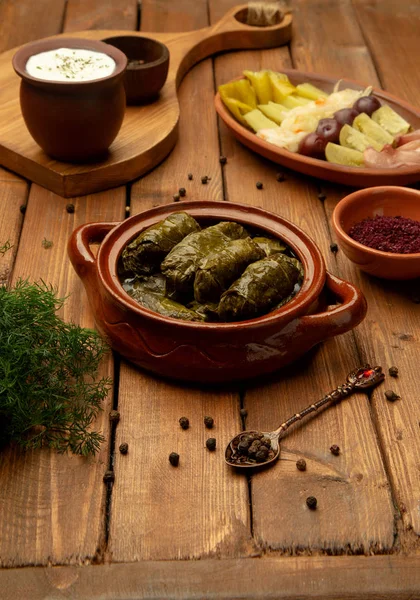 Leaves dolma in pot with side pickles — Stock Photo, Image