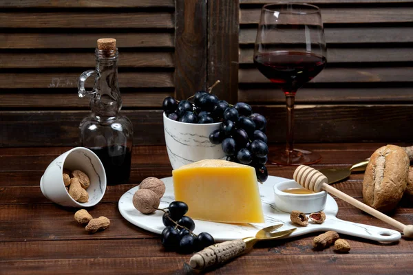 Fetta di parmigiano servita con vino e uva — Foto Stock