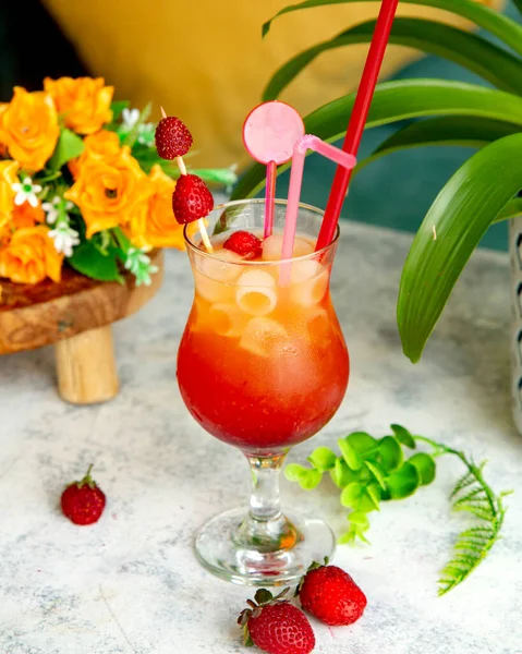 Tropensaft mit viel Eis und Erdbeeren drauf — Stockfoto