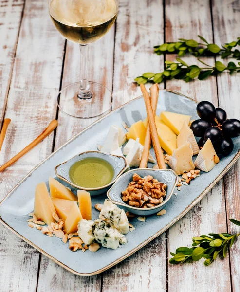 Käseteller mit knusprigen Stangen und Trauben — Stockfoto