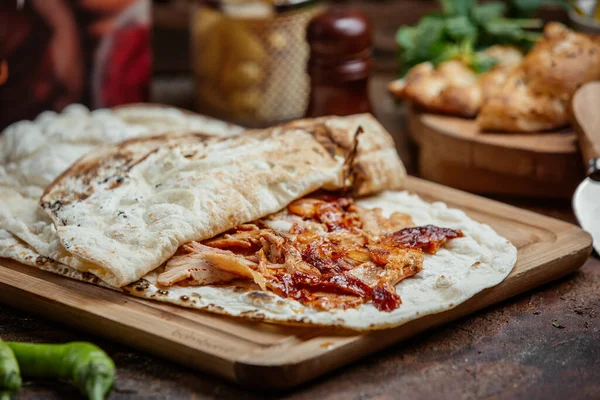 Poulet kebab donateur avec ketchup à l'intérieur de pain plat sur planche de bois — Photo