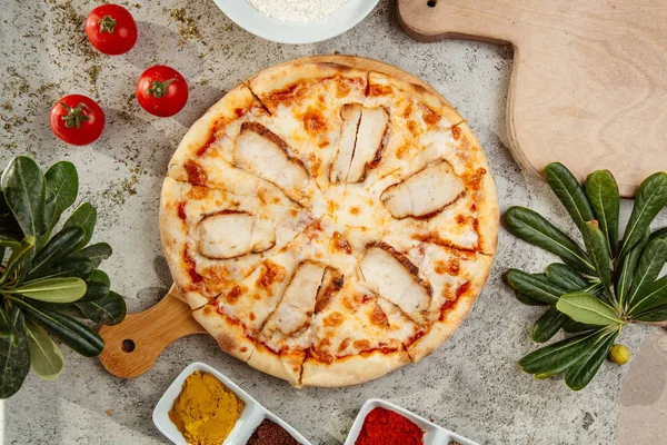 Kyckling pizza och några tomater på bordet — Stockfoto