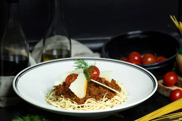 Espaguetis boloñeses adornados con tomates cherry y rodajas de parmesano —  Fotos de Stock