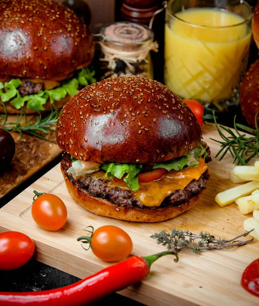Cheeseburger mięsny w miękkim chlebie i frytki na drewnianej desce — Zdjęcie stockowe