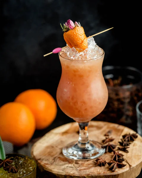 Склянка коктейлю з крижаним апельсином прикрашена апельсиновою цедрою у формі полуниці — стокове фото