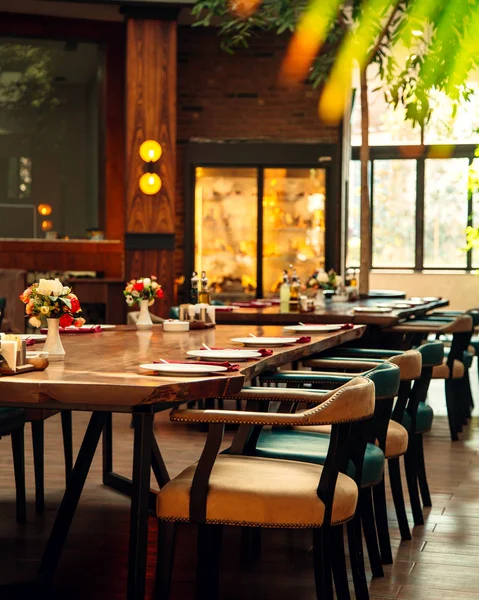Deri sandalyeli ve ahşap masalı restoran salonu.