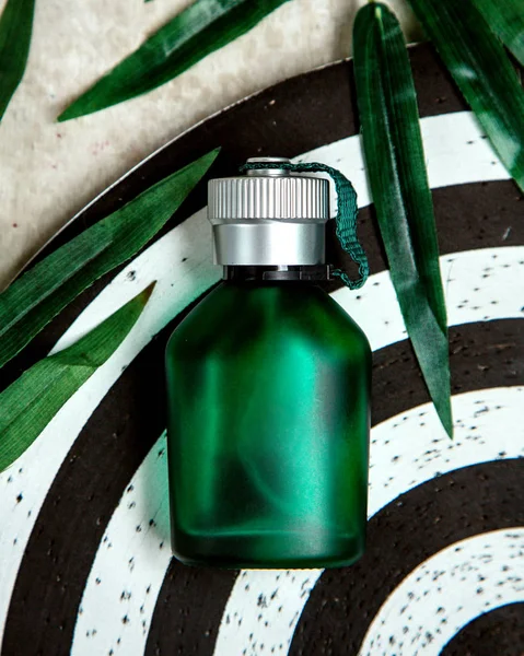 Botella verde de parfum sobre la mesa — Foto de Stock