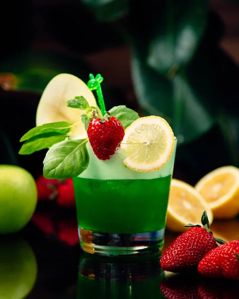 Зеленый коктейль с ломтиками лимона и клубникой — стоковое фото
