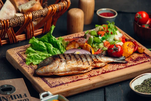 Taze sebze salatası, marul ve sumac parçacıklı ızgara balık.