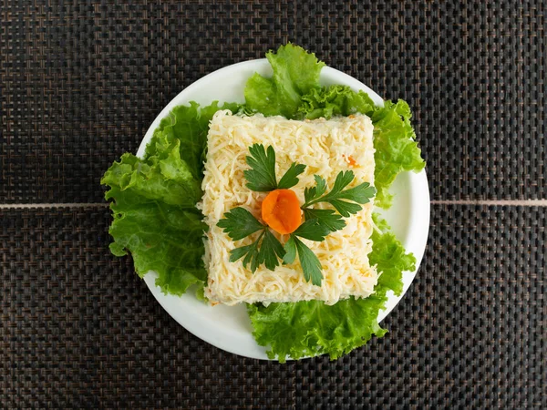 Салат из мимозы, украшенный петрушкой и цветком моркови — стоковое фото