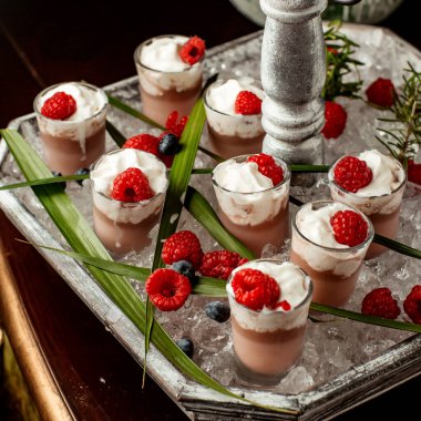 Krem şantili çikolatalı puding ve shot bardaklı ahududu.