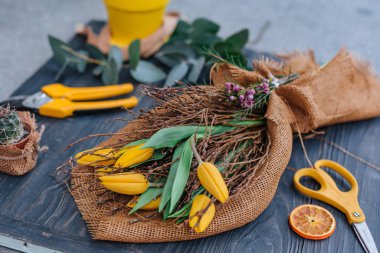 Masanın üzerinde sarı çiçekler olan buket.