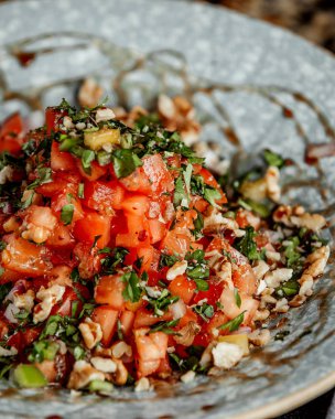 Doğranmış domates ve bitkilerle karışık salata.