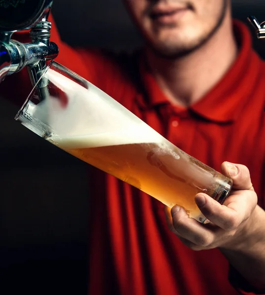 Barman derrama cerveja em um copo — Fotografia de Stock