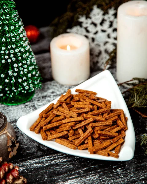 Spicy brown crackers in plate — Stock Photo, Image