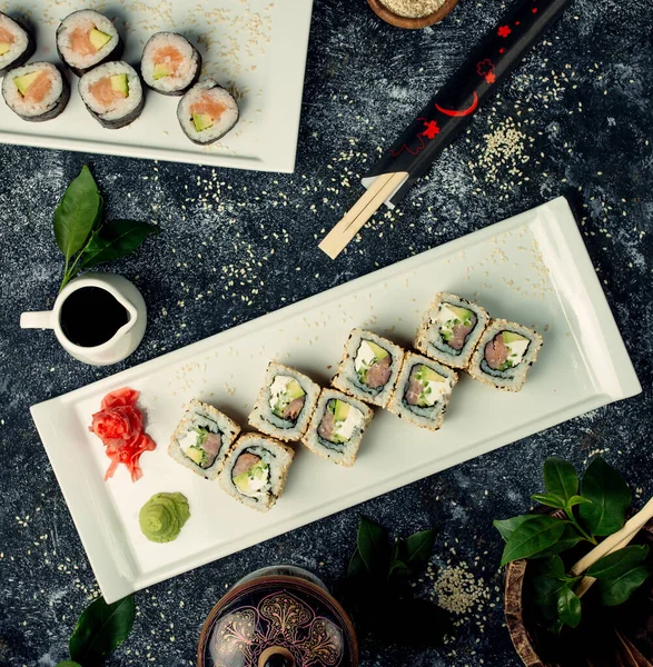 Vue de dessus des assiettes de sushi avec saumon et avocat — Photo