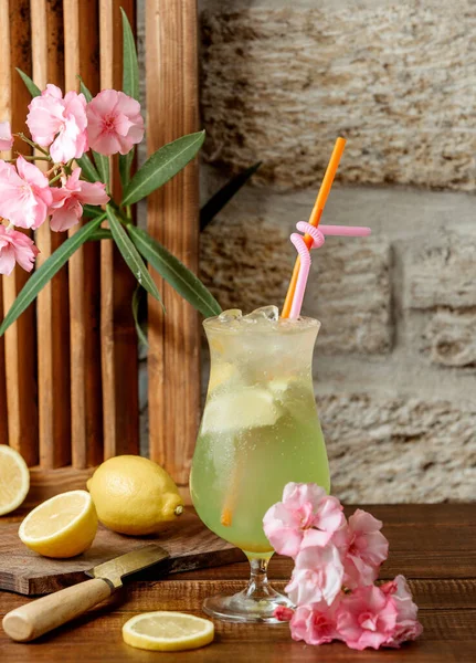 Glass of lemon cocktail with lemon pieces and two staws — Stock Photo, Image