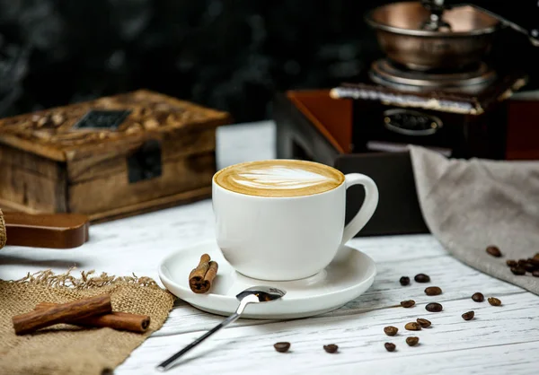 Uma xícara de cappuccino e canela — Fotografia de Stock