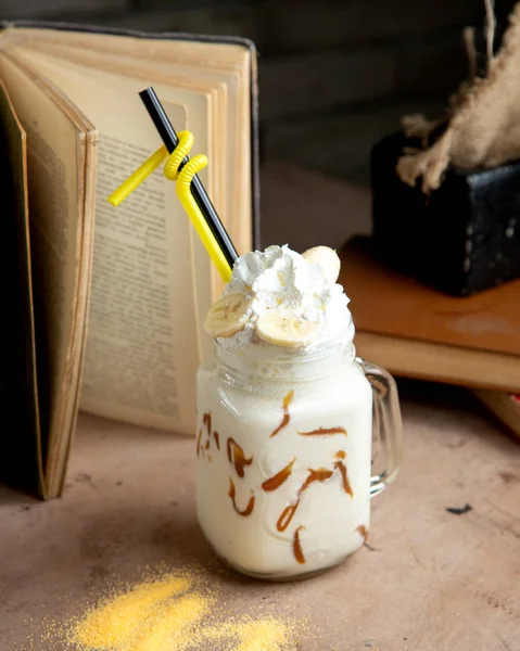 Ein Einmachglas mit Vanille-Milchshake und Schokoladensirup Schlagsahne und Banane — Stockfoto