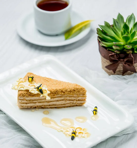 Свежий медовый торт с чаем на столе — стоковое фото