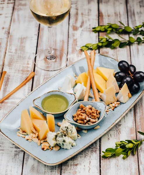 Assiette avec différents fromages et un plat avec du miel — Photo