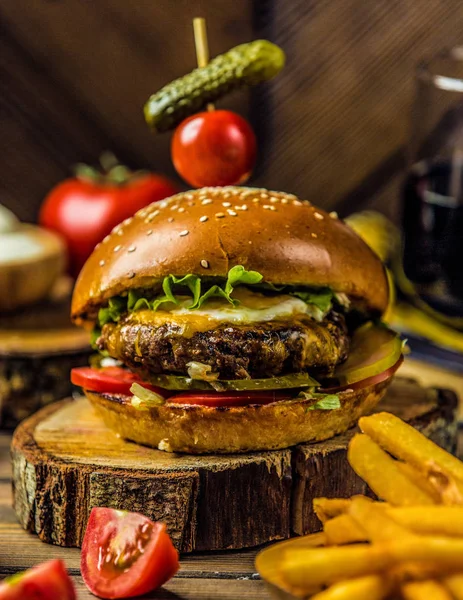 Burger wołowy z sałatą, ogórek marynowany, pomidor, podawany z frytkami — Zdjęcie stockowe