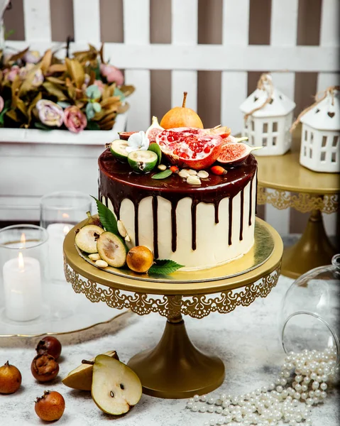 Gräddig kaka toppad med choklad och flera frukter — Stockfoto