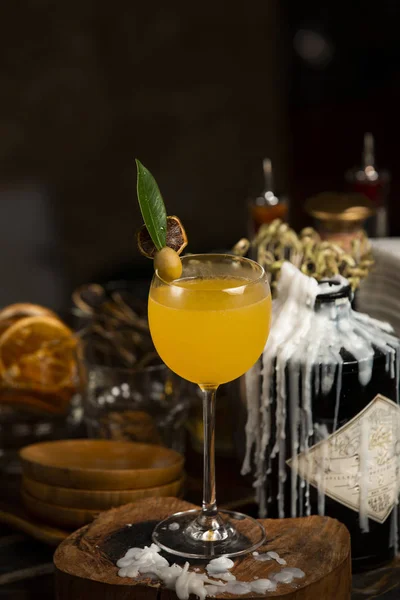 Апельсиновий сік у стоячому довгому стовбуровому келиху, прикрашеному оливковою олією — стокове фото