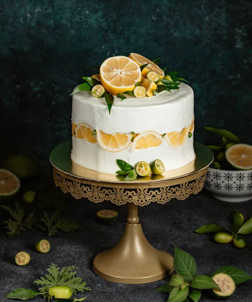 Lemon cake decorated with white cream and citrus fruits — Stock Photo, Image