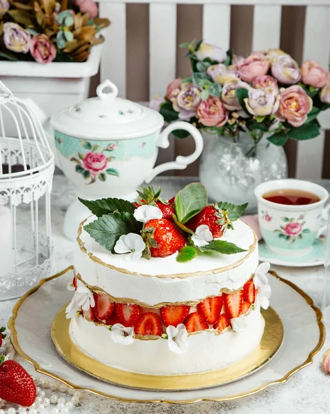 Creamy strawberry cake topped with fresh strawberries and leaves — Stock Photo, Image