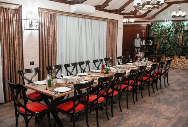 18 fős asztal vacsorához fekete fa székekkel piros ülésekkel — Stock Fotó