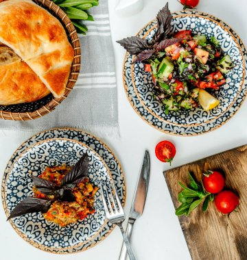 Masanın üstünde taze salatalar var.